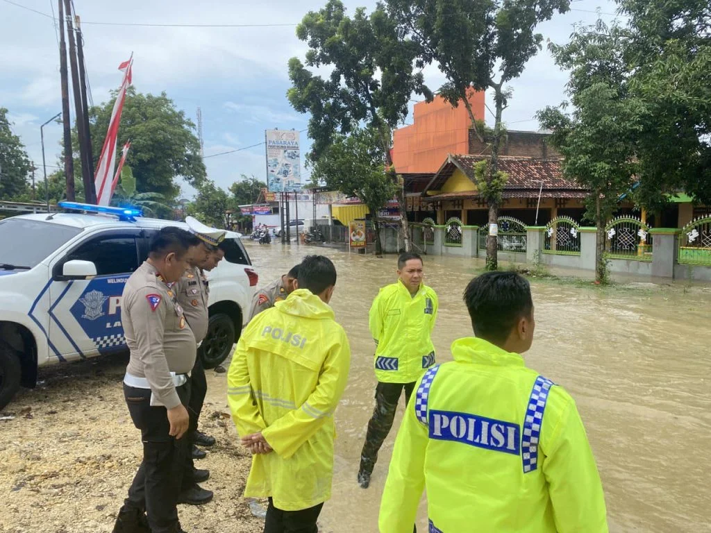 Petugas kepolisian mengatur arus lalu lintas saat terjadi Banjir Pertigaan Ketapang Grobogan.