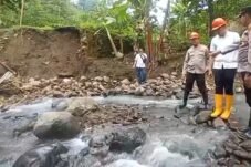 Petugas dan warga meninjau kondisi jembatan ambrol di aliran sungai berbatu di Dukuh Bongkar, Desa Nglumpit, Kecamatan Tlogowungu, Kabupaten Pati.