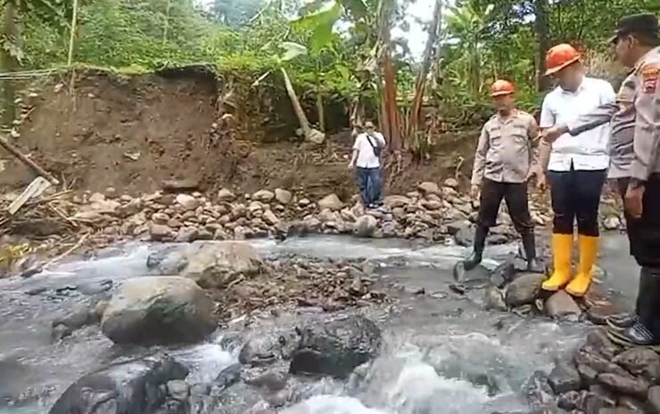 Petugas dan warga meninjau kondisi jembatan ambrol di aliran sungai berbatu di Dukuh Bongkar, Desa Nglumpit, Kecamatan Tlogowungu, Kabupaten Pati.