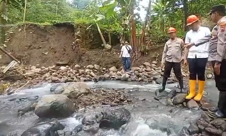 Petugas dan warga meninjau kondisi jembatan ambrol di aliran sungai berbatu di Dukuh Bongkar, Desa Nglumpit, Kecamatan Tlogowungu, Kabupaten Pati.