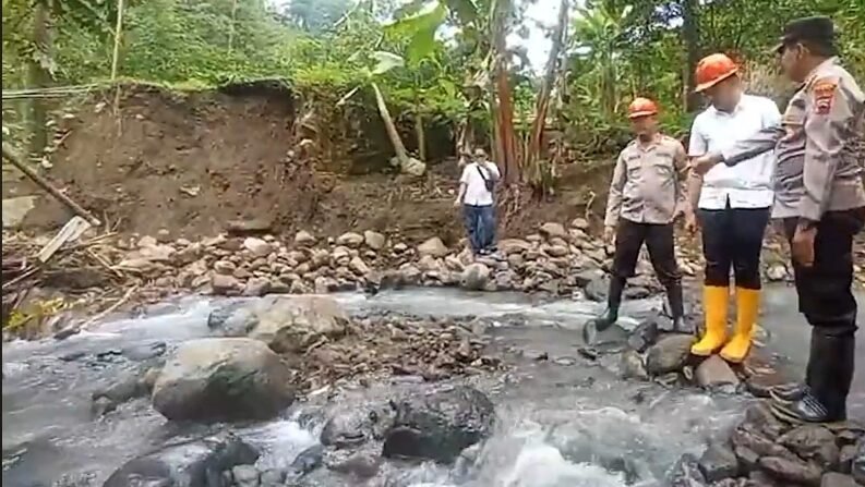 Petugas dan warga meninjau kondisi jembatan ambrol di aliran sungai berbatu di Dukuh Bongkar, Desa Nglumpit, Kecamatan Tlogowungu, Kabupaten Pati.