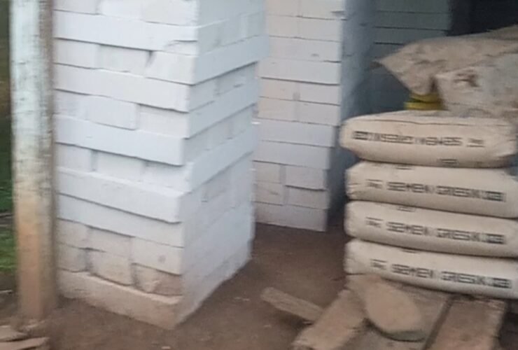 Tumpukan batako putih tersusun rapi di area pembangunan RTLH, dengan beberapa karung semen yang sudah membatu dan papan kayu yang sudah rusak dimakan rayap di sisi kanan di atas lantai tanah rumah penerima RTLH desa Cabak Kecamatan Tlogowungu Kabupaten Pati