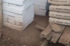 Tumpukan batako putih tersusun rapi di area pembangunan RTLH, dengan beberapa karung semen yang sudah membatu dan papan kayu yang sudah rusak dimakan rayap di sisi kanan di atas lantai tanah rumah penerima RTLH desa Cabak Kecamatan Tlogowungu Kabupaten Pati