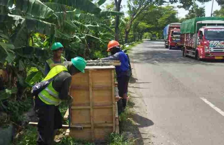 Pekerja memasang fasilitas Penerangan Jalan Umum Rembang di ruas jalur Pantura untuk keamanan warga.