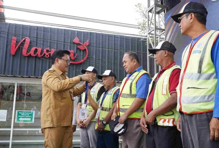 Petugas memasang barcode QRIS e-Parkir saat peluncuran uji coba sistem parkir digital di Jalan Monginsidi, Kota Salatiga.